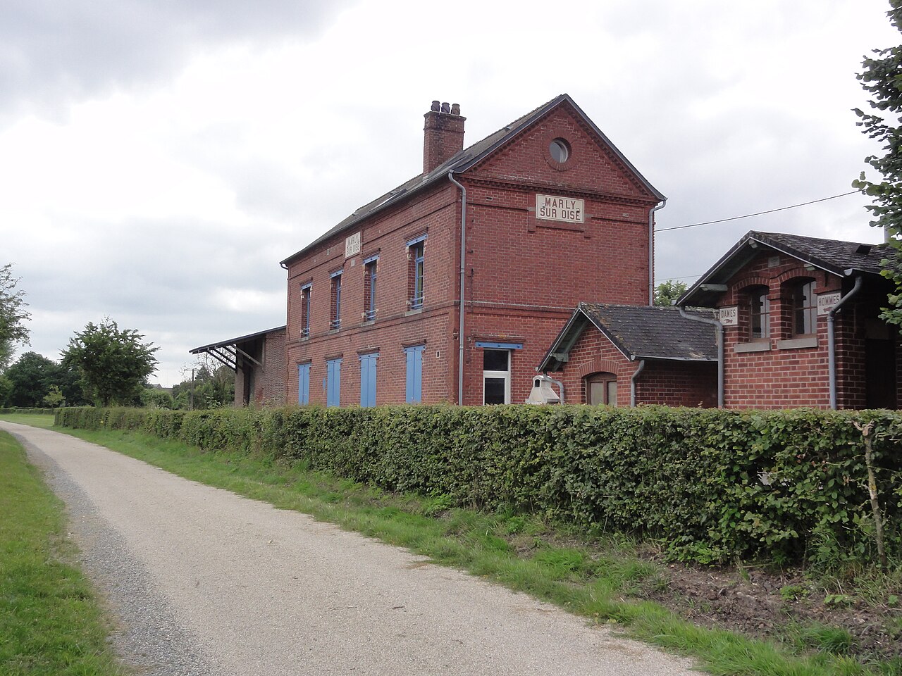 Ancienne gare de Marly-sur-Oise en brique rouge, bordée par la voie verte de l'Axe vert de la Thiérache